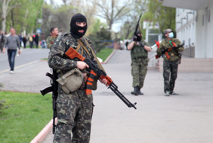  Milisi pro-Rusia bersenjata lengkap berjaga di jalan raya di kota Lugansk, Ukraina, Selasa (29/4).