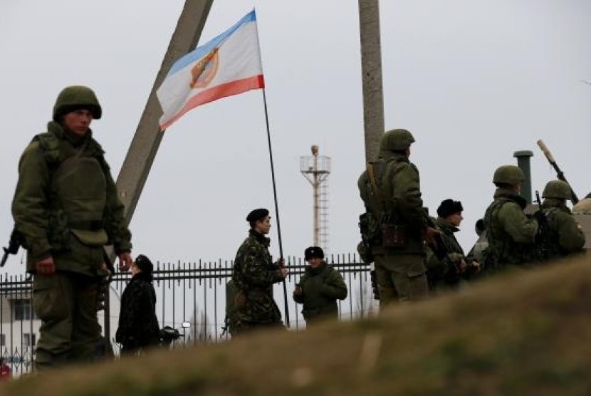 Military personnel stand guard in the Crimean port city of Feodosiya March 2, 2014.