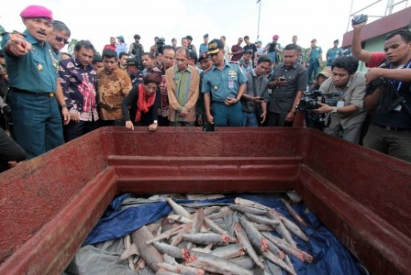 Minister of Maritime and Fishery Affairs Susi Pudjiastuti (center with red scarf) inspects an illegal fishing boat in Ambon, Maluku, on Thursday.  