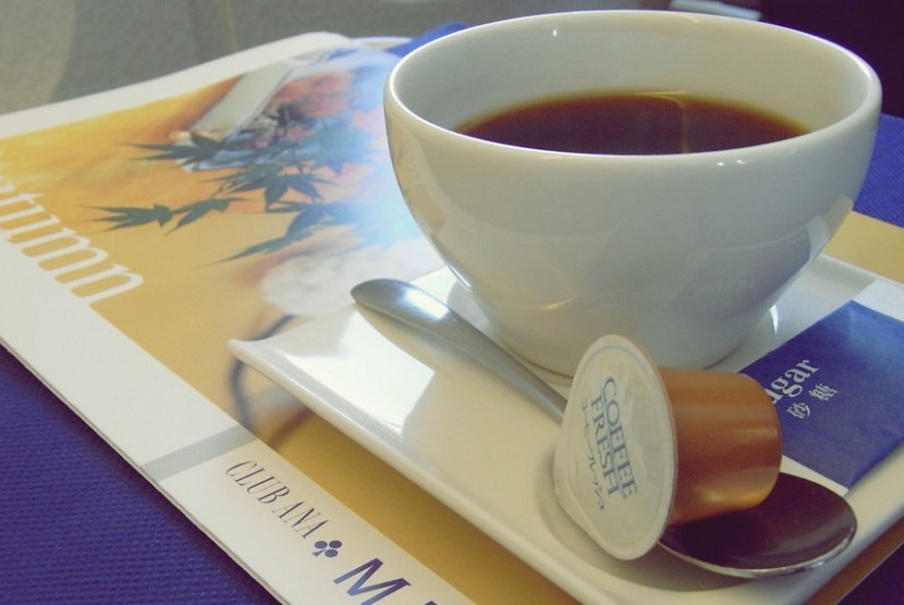 Minum kopi di atas pesawat.