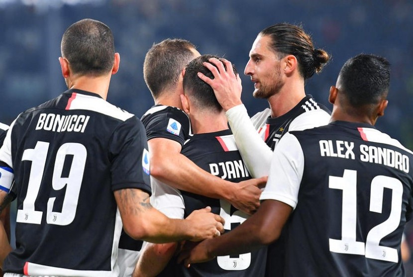 Miralem Pjanic (tengah) merayakan gol kemenangan Juventus yang dicetaknya ke gawang Bologna.