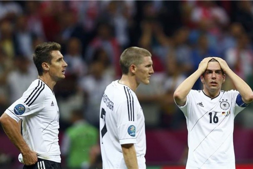 Miroslav Klose (kiri), Bastian Schweinsteiger (tengah), dan Philipp Lahm tampak kecewa setelah Jerman menelan kekalahan 1-2 dari Italia di semifinal Piala Eropa 2012. 
