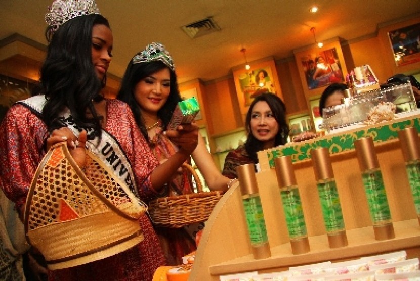 Miss Universe 2011 Leila Lopes (kiri) dan Putri Indonesia 2011 Maria Selena (tengah) didampingi Presiden Direktur PT Mustika Ratu Putri Kuswisnu Wardani (kanan), mengamati produk pasta gigi berbahan daun sirih saat melakukan kunjungan ke gerai Java Princes