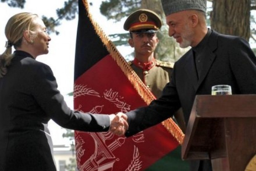 Mitra utama: Hillary Clinton berjabat tangan dengan presiden Afghanistan Hamid Karzai setelah konferensi pers.  