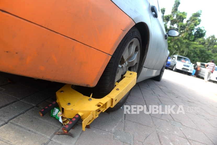  Mobil dengan gembok roda diparkir di kawasan IRTI, Monas, Jakarta, Selasa (3/1).