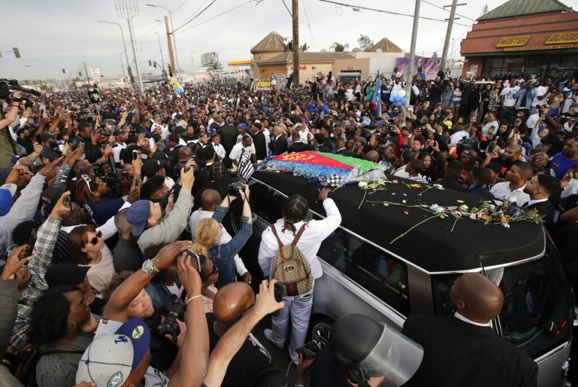 Mobil jenazah membawa mendiang rapper Nipsey Hussle yang dibungkus bendera asal ayahnya, Eritrea di Afrika Timur, melewati jalanan, Kamis (11/4) waktu Los Angeles. 