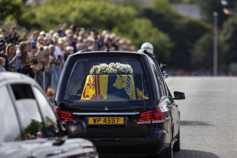 Mobil jenazah yang membawa peti mati Ratu Elizabeth II, terbungkus Standar Kerajaan Skotlandia, melewati Aberdeen, Skotlandia, Minggu, 11 September 2022 saat melanjutkan perjalanannya ke Edinburgh dari Balmoral.