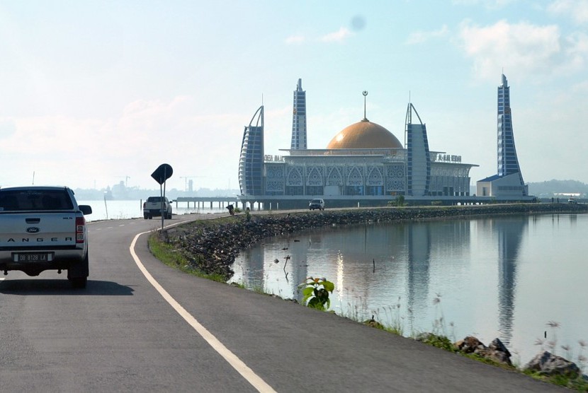Mobil melintasi Masjid Al-Alam, Kota Kendari, Sulawesi Tenggara. Hasil rapat pleno PWI Pusat dan Dewan Pers menetapkan Sultra sebagai tuan rumah HPN 2020. Ilustrasi.