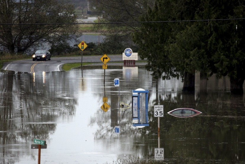 Mobil mendekati kawasan yang terkena banjir di kawasan Stanwood, Washington. Badai mengakibatkan banjir dan pemadaman listrik, Rabu (18/11).