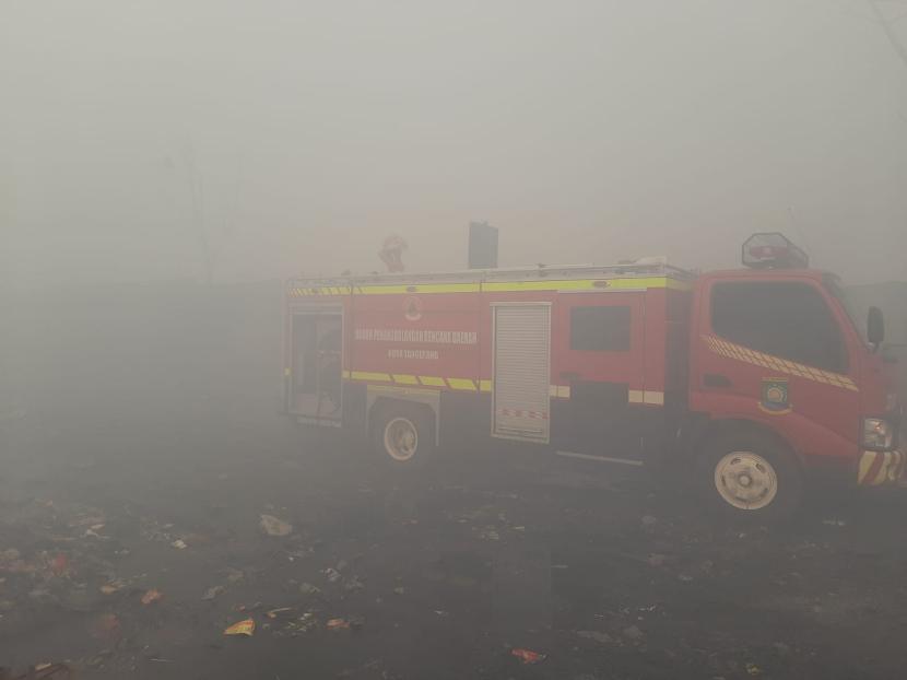 Mobil pemadam kebakaran bersiaga di sekitar TPA Rawakucing yang terbakar di Kota Tangerang, Banten, Senin (23/10/2023). Warga Rawakucing tak percaya klaim api sudah didinginkan karena asap masih pekat