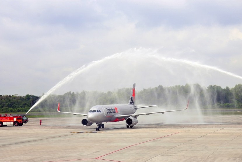 Mobil pemadam kebakaran menyemprotkan air untuk menyambut penerbangan perdana pesawat Jetstar di Bandara Sultan Syarif Kasim II, Pekanbaru, Riau