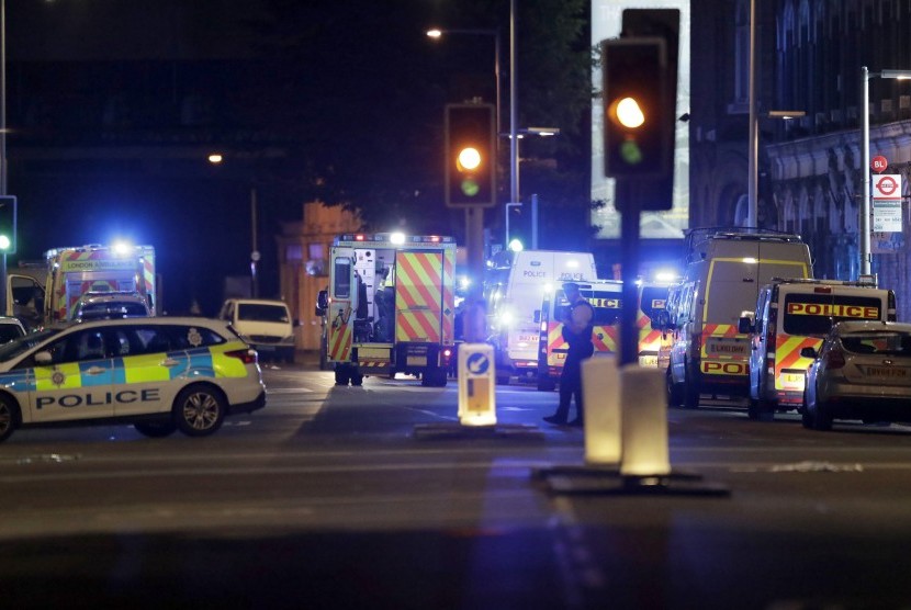 Mobil polisi terparkir di Jembatan London setelah insiden van yang menabrakkan kendaraannya di jalur pedesterian, Ahad (4/6).