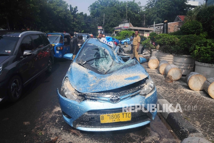 Mobil taksi dengan nopol B 1606 TTC ringsek tertimpa pohon di Jalan Fachrudin, Tanah Abang, Jakarta Pusat, Selasa (30/8).  (Republika/Agung Supriyanto)