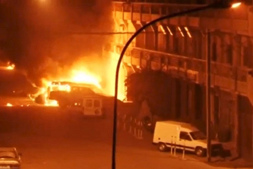 Mobil terbakar di depan Hotel Splendid, Burkina Faso, lokasi penyanderaan pada Jumat (15/1).