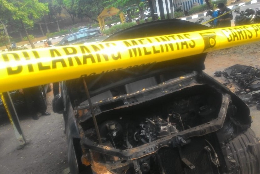Mobil Xenia warna hitam Nopol B 1247 EKC terongok dan dipasang garis polisi di bengkel mobil di Jalan M Yasin, Kelapa Dua, Cimanggis, Depok. Mobil tersebut merupakan mobil milik Neno Warisman yang terbakar.