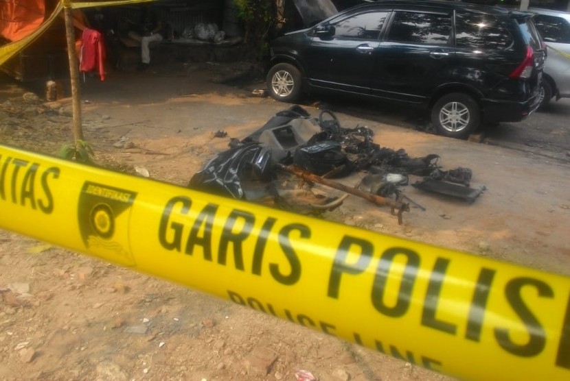 Mobil Xenia warna hitam Nopol B 1247 EKC terongok dan dipasang garis polisi di bengkel mobil di Jalan M Yasin, Kelapa Dua, Cimanggis, Depok. Mobil tersebut merupakan mobil milik Neno Warisman yang terbakar.