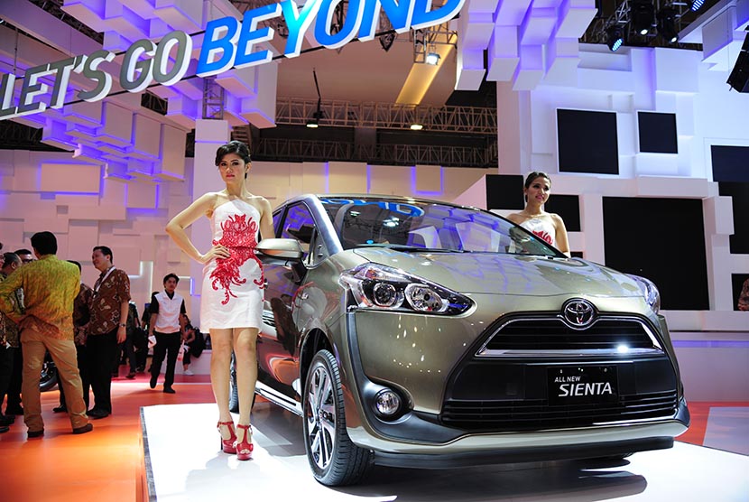 Model berpose di samping mobil terbaru sebuah kendaraan jenis  'multi activity vehicle' (MAV),  Toyota Sienta saat diperkenalkan di arena IIMS 2016 di Jakarta, Kamis (7/4). 