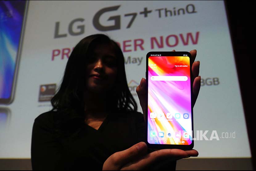 Model memperlihatkan handphone LG G7+ ThinQ (ilustrasi). 