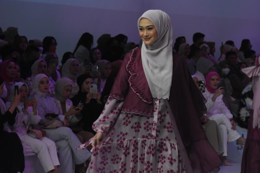 Model mengenakan busana koleksi Hijabchic pada Jakarta Fashion Week (JFW) 2023 di Jakarta, Sabtu (29/10/2022). Label Jenna & Kaia, naPocut, dan Hijabchic menamplkan desain busana bertema Woman in Rhythm yang merepresentasikan citra dalam balutan busana perempuan yang penuh warna dan berkarakter. 
