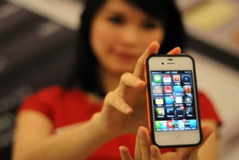 Model menunjukan iPhone 4s saat penjualan perdana di salah satu pusat perbelanjaan di Jakarta, Jumat (27/1). (Republika/Wihdan Hidayat)