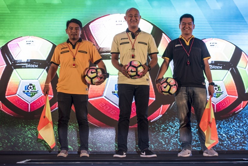 Model menunjukan kaos wasit dan bola yang akan digunakan dalam penyelenggaraan kompetisi Liga 1 di Jakarta, Senin (10/4).