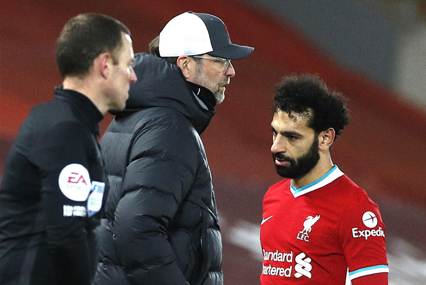 Striker Liverpool Mohamed Salah berjalan melewati pelatihnya, Juergen Klopp.