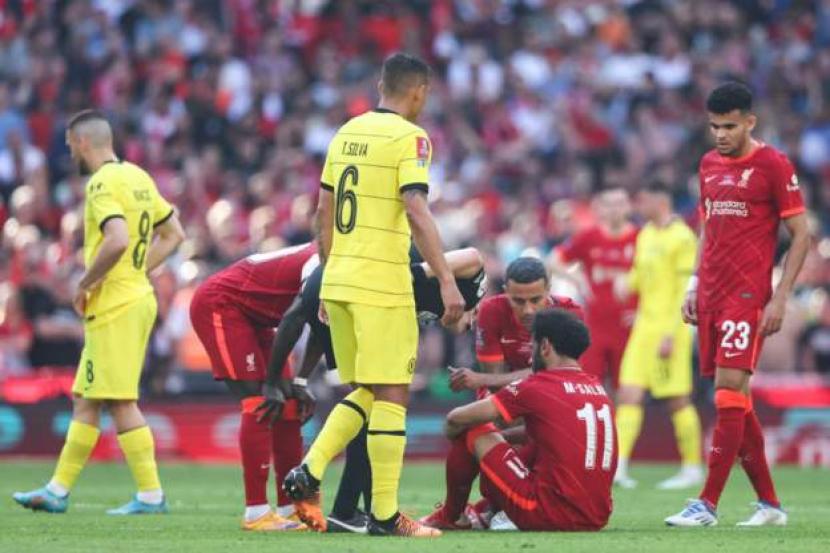 Striker Liverpool Mohamed Salah (duduk) cedera saat melawan Chelsea di final Piala FA, Ahad (15/5/2022).