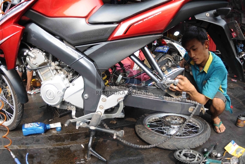 Montir memperbaiki kendaraan bermotor di salah satu bengkel di Kawasan Pasar Minggu, Jakarta Selatan, Rabu (1/7). (Republika/Agung Supriyanto)