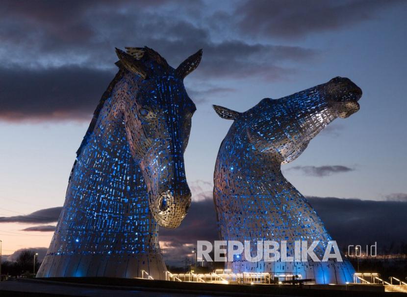 Monumen sosio-historis Kelpies menyala dengan warna biru sebagai penghargaan untuk menghormati Sistem Kesehatan Nasional (NHS) dan pekerja perawatan, di Falkirk, Skotlandia. Inggris akan kucurkan dana 1,57 miliar poundsterling untuk institusi budaya terdampak Covid-19. Ilustrasi. 
