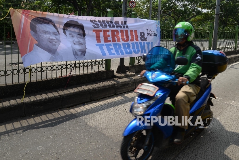 Motor melintas di sebelah spanduk duet Ahok-Djarot terpampang di Jalan Sultan Agung, Jakarta Pusat, Kamis (28/7). (Republika/ Yasin Habibi)