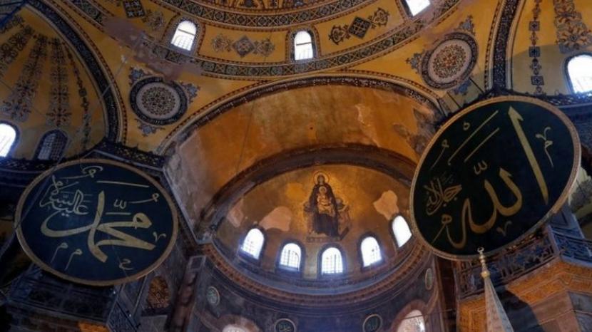 Mozaik Bunda Maria tergambar di langit-langit dan diapit kaligrafi Allah dan Muhammad di Masjid Hagia Sophia.