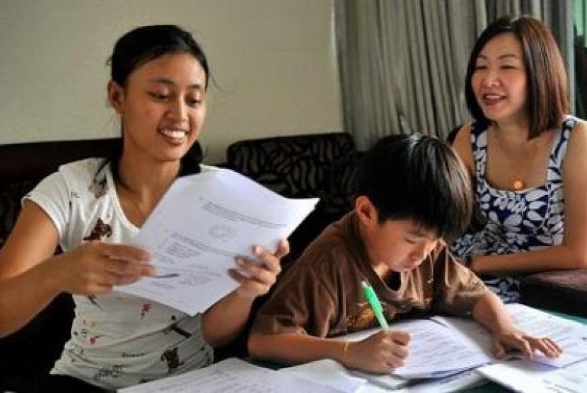 Mrs Eileen Tjandra (right), 42, dengan putranya, Chirstoper, 9, dan PRT Indonesia, Yuli, 26 tahun. Eileen membayar Yuli 520 dolar Singapura sebulan, di atas rata-rata pasar untuk PRT berpengalaman.