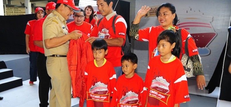 Mudik Kapal Laut: Walikota Makassar Ilham Arief Sirajuddin (kiri) memberikan jaket kepada peserta mudik akbar gratis TELKOMSELsiaga sebagai simbolisasi pelepasan mudik kapal laut di Pelabuhan Makassar