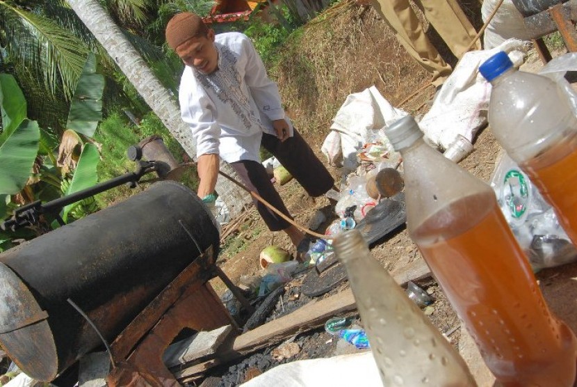 Muhammad Afdal (31), membakar sampah plastik di sebuah tabung, di halaman rumahnya di Desa Pakasai, Kec.Pariaman Timur, Kota Pariaman, Sumbar, Selasa (28/2). Afdal berhasil membuat Bahan Bakar Minyak (BBM) dan gas dengan melebur limbah (sampah) plastik yan