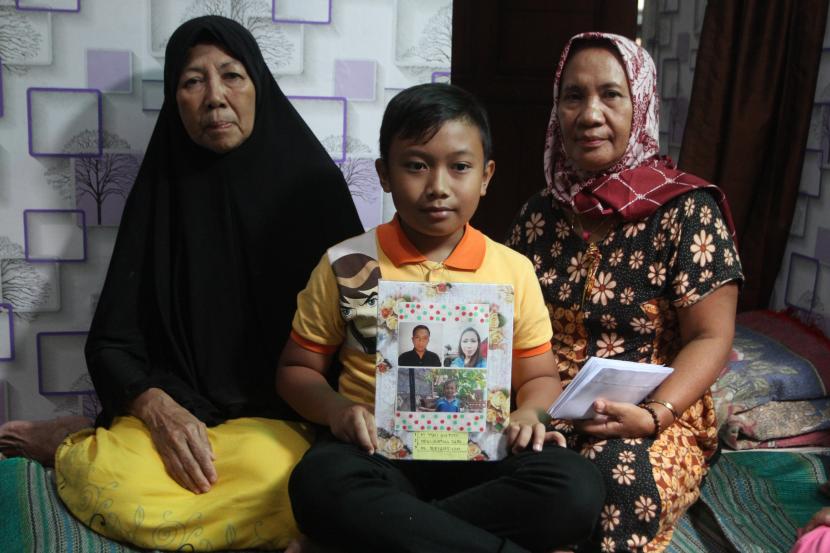 Muhammad Alfiansyah (tengah) duduk bersama kedua neneknya di rumahnya di Bareng, Malang, Jawa Timur, Senin (3/10/2022). Pelajar berusia 11 tahun tersebut merupakan korban selamat namun kedua orang tuanya meninggal dunia dalam tragedi Stadion Kanjuruhan yang turut menewaskan ratusan orang. 