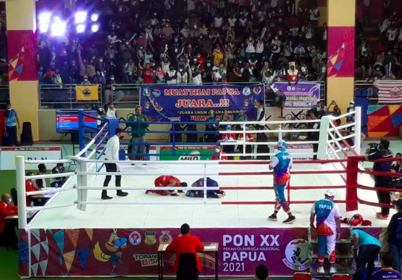 Muhammad Bayan Hamid atlet putra muaythai Papua (merah) dan Galih Bangkit atlet muaythai Jawa Timur (biru) menujukkan rasa syukur dan hormat usai bertanding di GOR STT GIDI, Papua, Ahad