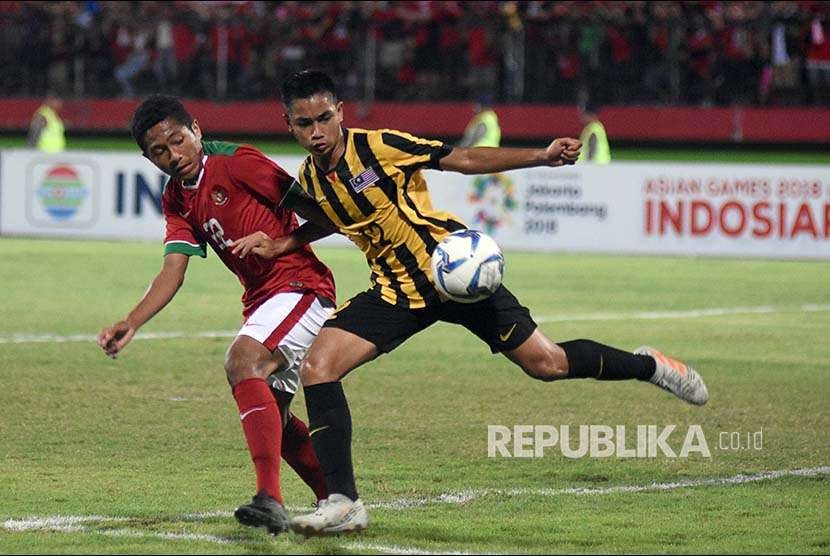 Muhammad Fajar Fathur Rachman (kiri) berebut bola dengan pesepak bola Malaysia U-16 Mohammad Marwan Abdul Rahman (kanan) pada laga semifinal Piala AFF U-16 di Stadion Gelora Delta Sidoarjo, Jawa Timur, Kamis (9/8).