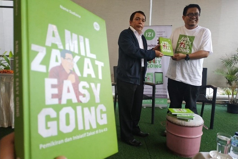 Muhammad Fuad Nasar (kiri), Direktur Pemberdayaan Zakat dan wakaf Kemenag RI menerima buku Amil Zakat Easy Going karya Nana Sudiana, Sekjend FOZ & Direktur IZI (kanan) dalam peluncuran buku tersebut di Jakarta, Rabu (9/10).