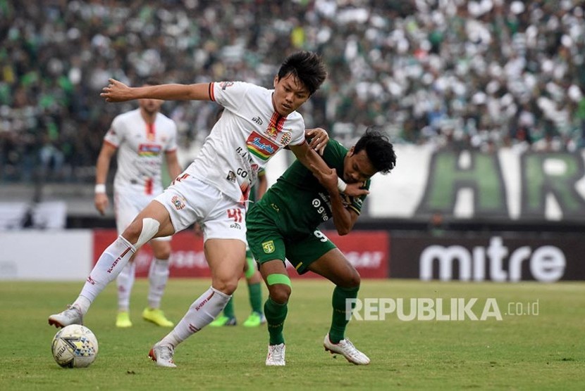 Muhammad Hidayat (kanan) dan Feby Eka Putra (kiri) berebut bola  pada pertandingan Liga 1 Indonesia di Stadion Gelora Bung Tomo, Surabaya, Jawa Timur, Sabtu (24/8).