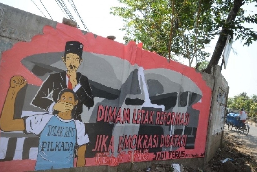 Mural penolakan UU Pikada terlihat di dinding beton di Jalan Kalimalang, Jakarta, Selasa (7/10).