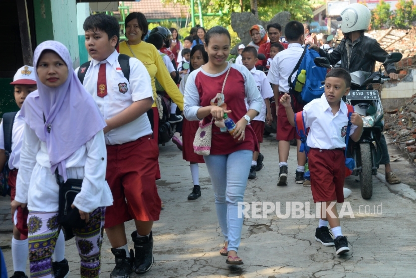 Orang tua mengantar anaknya ke sekolah 