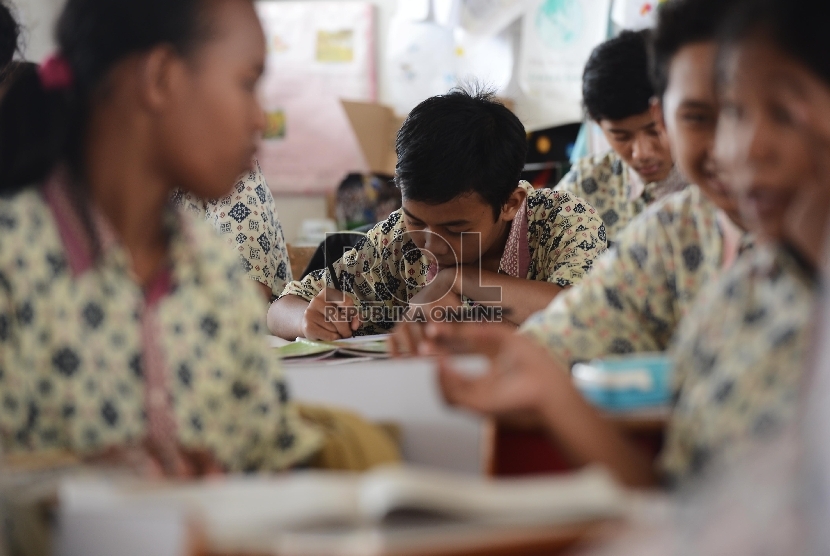 Murid kelas IX SMPN 65 melakukan kegiatan belajar mengajar di ruangan sementara di Sekolah Dasar Negeri 12 Pagi, Sunter Jakarta Utara, Kamis (16/4).(Republika/Raisan Al Farisi).