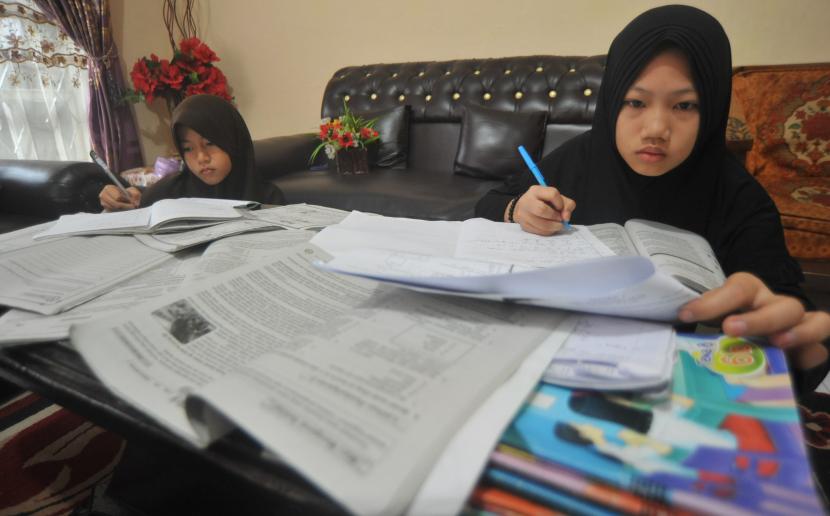 Murid sekolah dasar (SD) mengerjakan tugas dari sekolah di rumah, di Padang, Sumatra Barat, Jumat (20/3/20).