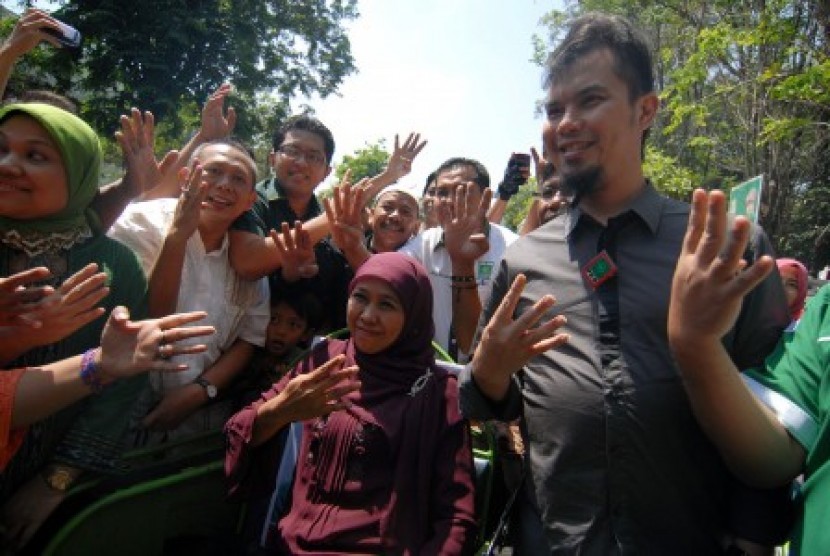  Musisi Ahmad Dhani (kanan) mendampingi Cagub Jawa Timur, Khofifah Indar Parawansa (tengah) saat kampanye di Jombang, Jawa Timur, Senin (19/8). Dalam kesempatan itu Ahmad Dhani menyempatkan menjadi tukang becaknya Khofifah Indar Parawansa sebagai bentuk du