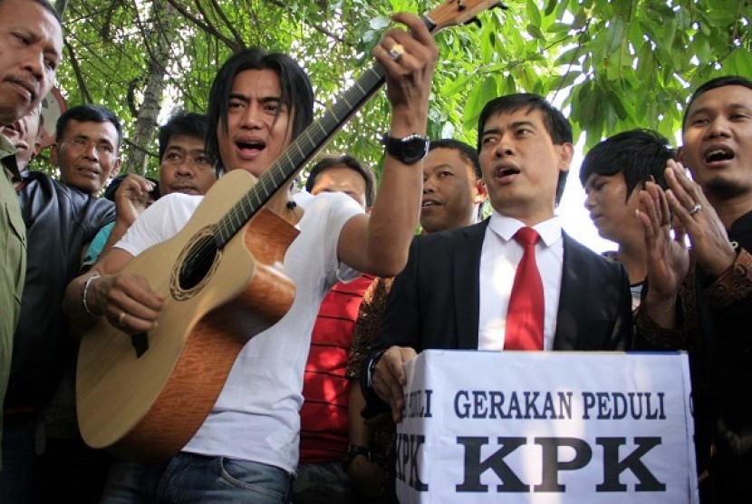 Musisi Charly Van Houten (tengah) bersama pengacara Ahmad Rifai (kanan) menggamen saat bergabung dalam gerakan peduli KPK di Kramat Sentiong, Jakarta, Rabu, (27/6). Gerakan tersebut sebagai sumbangan terhadap pembangunan gedung baru KPK dan hasil yang terk