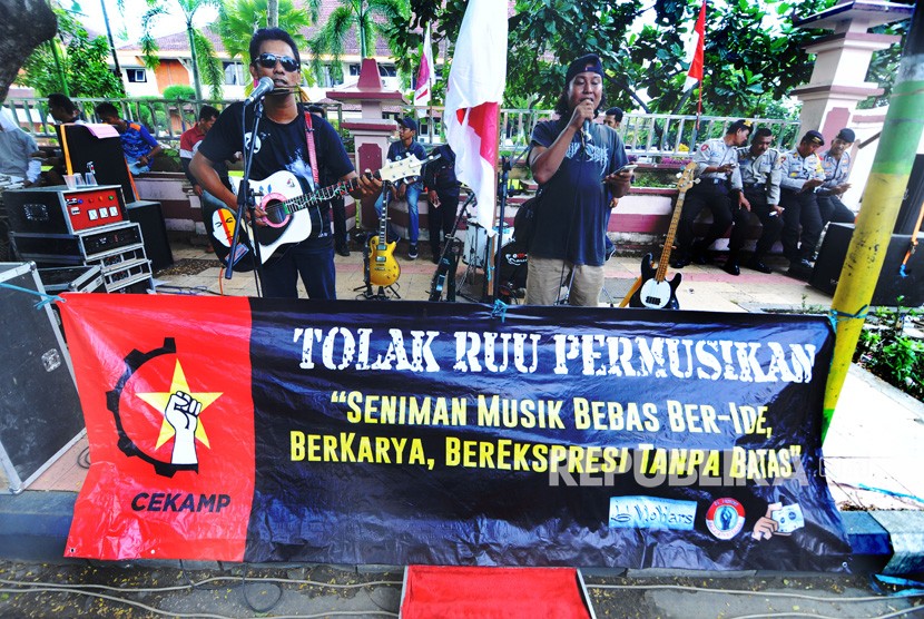 Musisi menyanyikan sejumlah lagu dari Iwan Fals ketika berunjuk rasa menolak RUU tentang Permusikan di depan kantor DPRD Pamekasan, Jawa Timur, Senin (18/2/2019). 