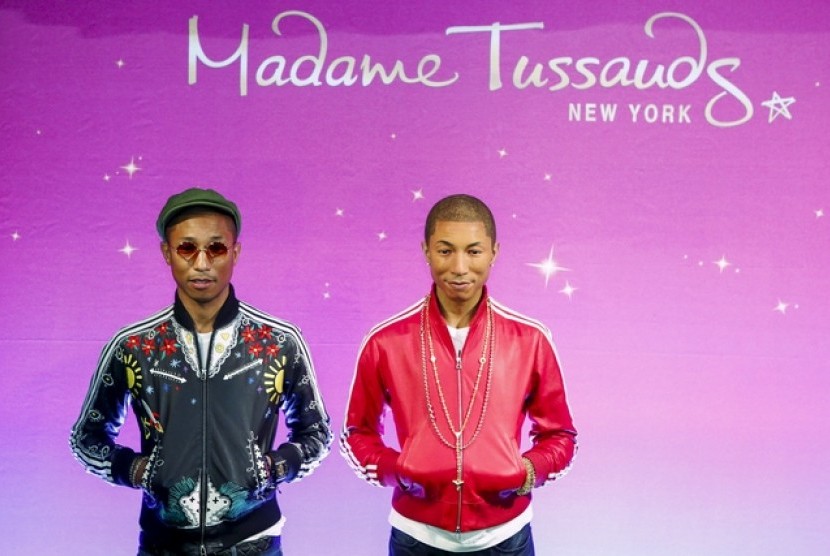 Musisi Pharrell Williams berpose di samping patung lilinnya di Museum Madame Tussauds New York.