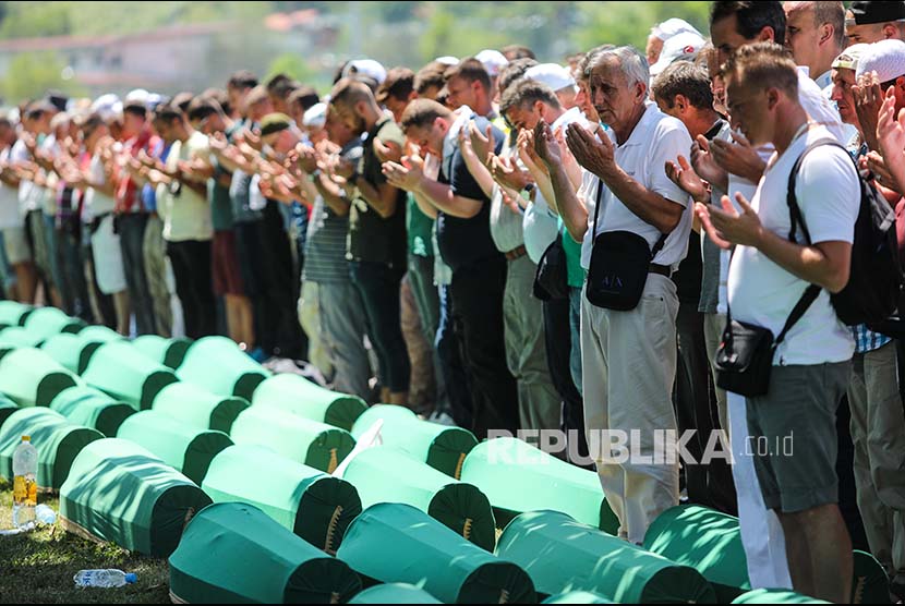 Muslim Bosnia memanjatkan doa sebelum penuguburan kembali sisa jenazah korban pembantaian Srebrenica pada tahun 1995 di Bosnia Herzegovina, Selasa (11/7).