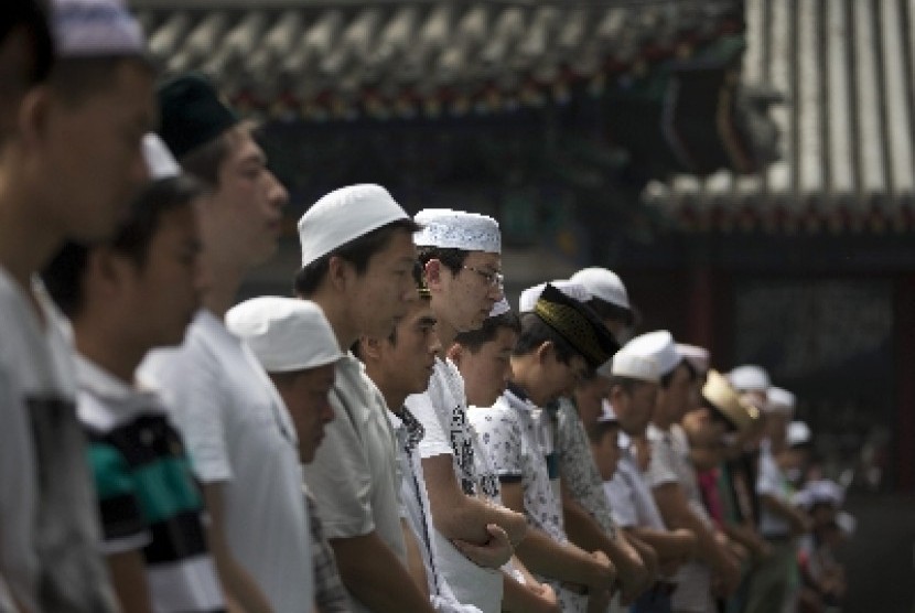 Muslim Cina dari kalangan etnis Hui tengah melaksanakan shalat. Muslim di Cina barat daya itu mencoba menghentikan upaya penghancuran atap kubah masjid berusia berabad-abad