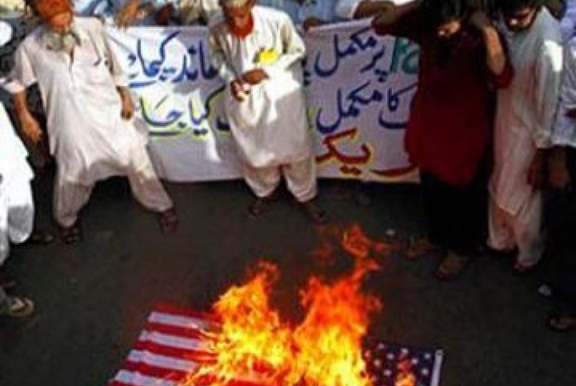 Muslim di Pakistan membakar bendera AS dan meneriakkan slogan anti-Amerika dalam demonstrasi pada 21 Mei 2010.